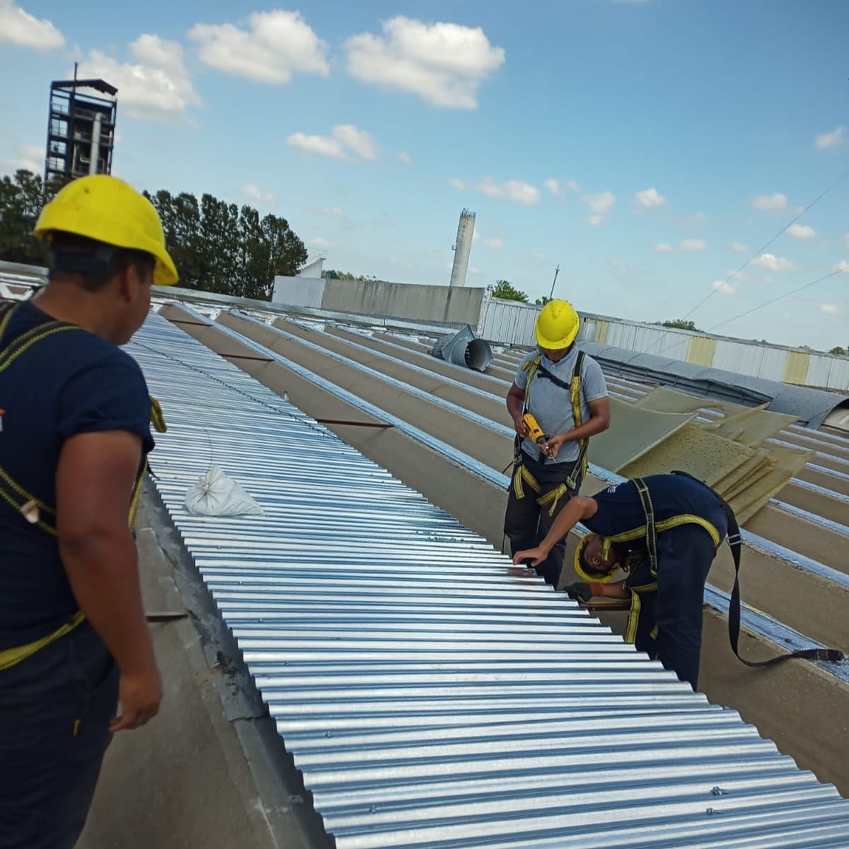 Trabajadores reparando el techo de una fábrica.